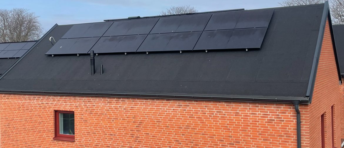 Solcellspaneler på nylagt papptak på tegelhus